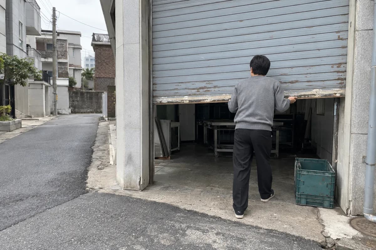 재물운 좋은 사주의 식상생재 흐름처럼 아침에 동네 작업실 셔터를 올리는 남성의 뒷모습