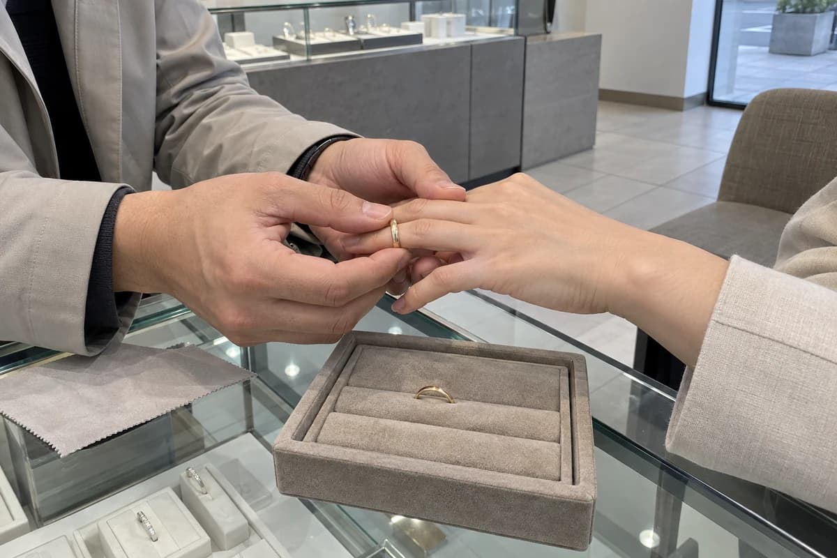 결혼 늦어지는 사주 대표 이미지, 보석 매장에서 결혼반지를 끼워 보는 두 사람의 손 wedding rings