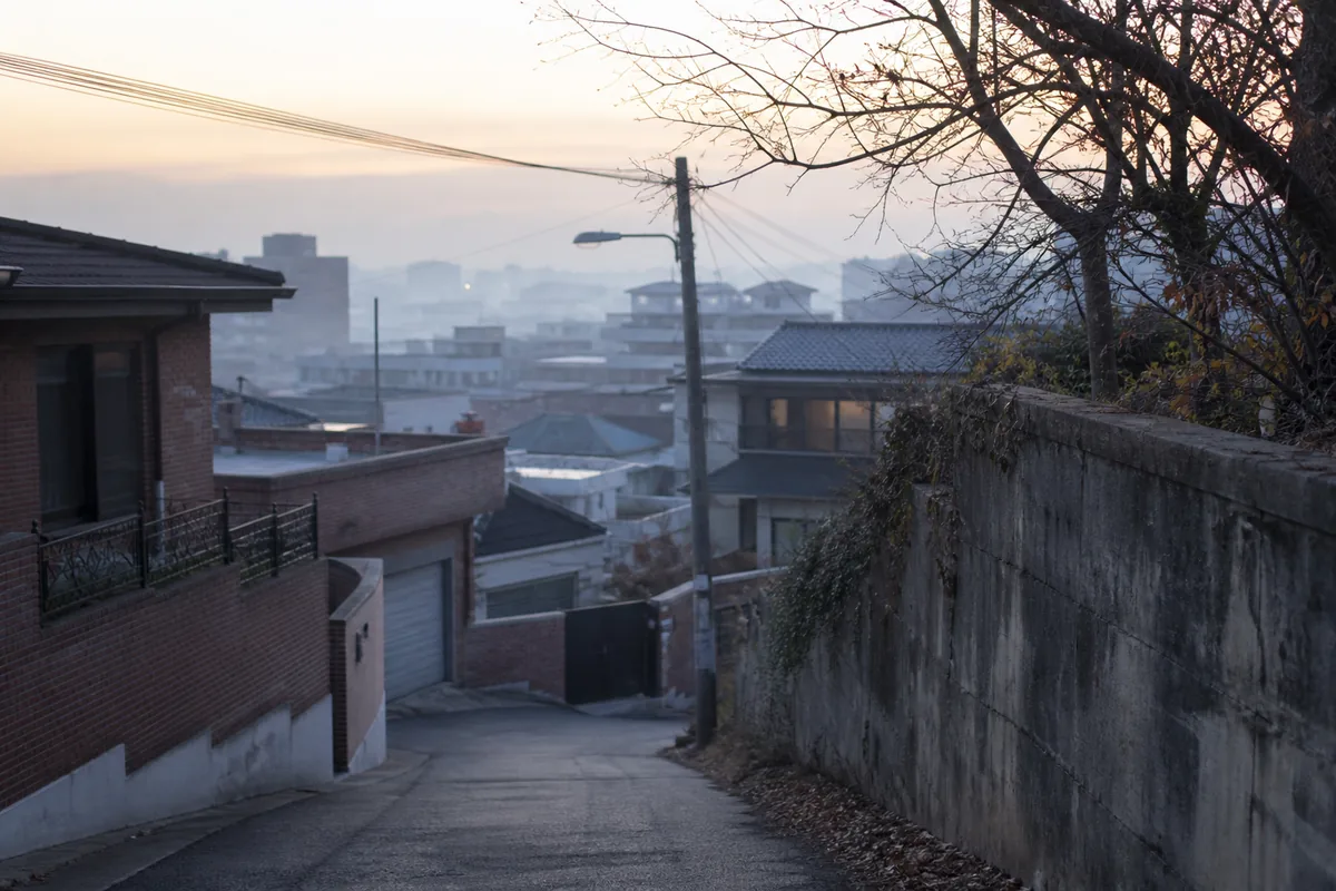 대운 바뀌는 시기의 전환감을 담은 사진으로, 안개가 낮게 깔린 이른 새벽 한국 주택가 골목이 비어 있는 모습