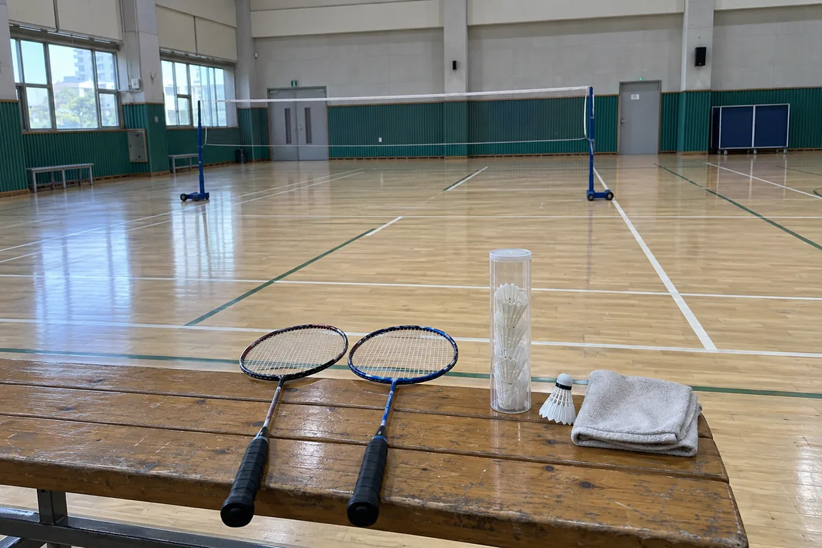 인복 없는 사주 마무리 이미지, 체육관 코트 옆 벤치에 놓인 배드민턴 라켓과 셔틀콕 a club night